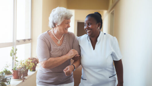 Portrait,Of,Smiling,Home,Caregiver,And,Senior,Woman,Walking,Together